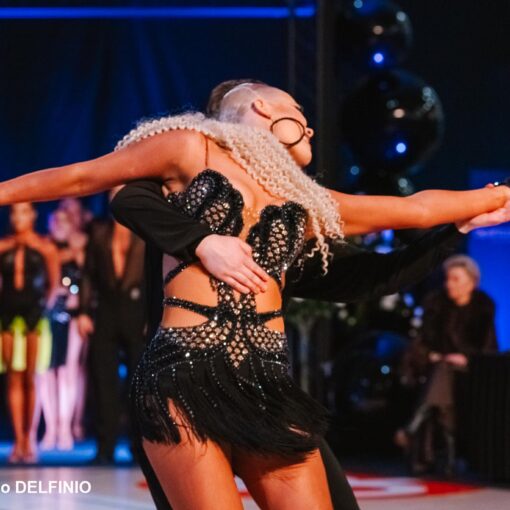 Tanssipari liikkeessä Latina SM -kilpailussa Salossa, taustalla yleisö ja odottavat parit.